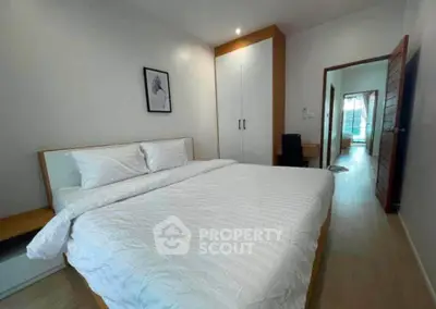 Spacious bedroom with modern decor and ample natural light, featuring a comfortable bed and stylish wardrobe.