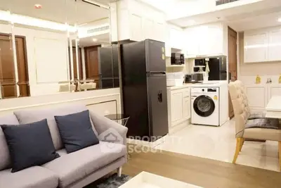 Modern open-plan living room with kitchen, featuring sleek appliances and stylish decor.