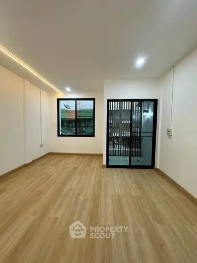 Spacious modern room with wooden flooring and large window view