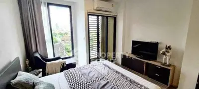 Modern bedroom with large window and balcony access in stylish apartment.
