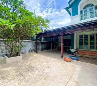 Charming house with spacious patio and lush greenery, perfect for outdoor relaxation.