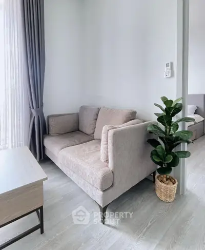 Modern living room with cozy sofa and natural light, perfect for relaxation.