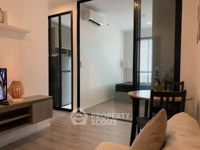 Modern apartment interior with cozy living room and glass-walled bedroom