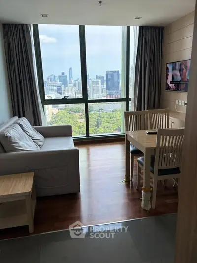 Modern living room with city view, featuring cozy sofa and dining area, ideal for urban living.