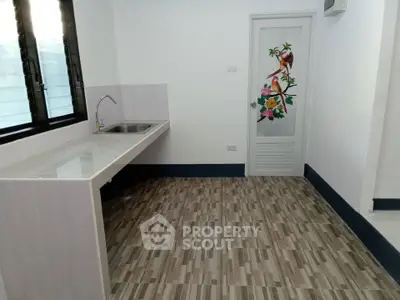 Spacious kitchen with modern sink and decorative door in a bright interior.