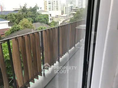 Spacious balcony with modern railing and city view, perfect for relaxation.