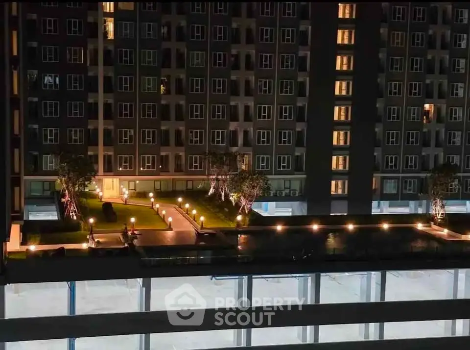 Stunning night view of modern apartment building with illuminated garden and pathway.