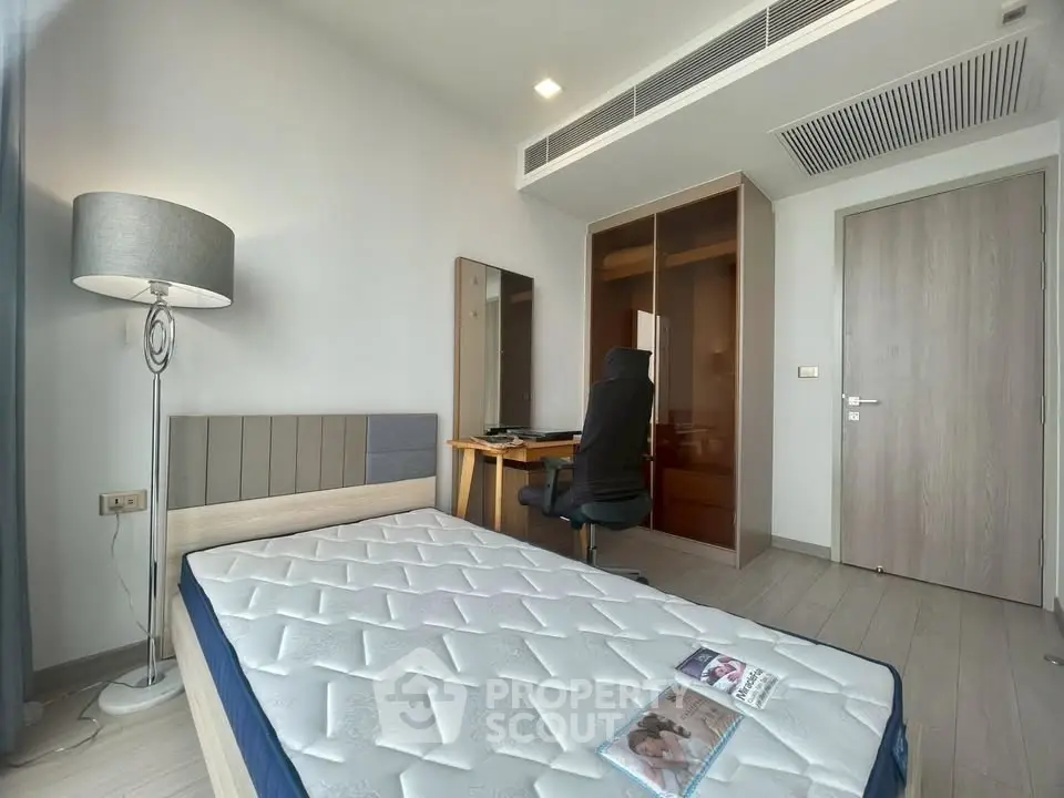 Modern bedroom with sleek furniture and natural light, featuring a comfortable bed and stylish decor.