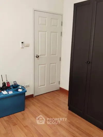 Cozy bedroom with wooden flooring and a sleek wardrobe