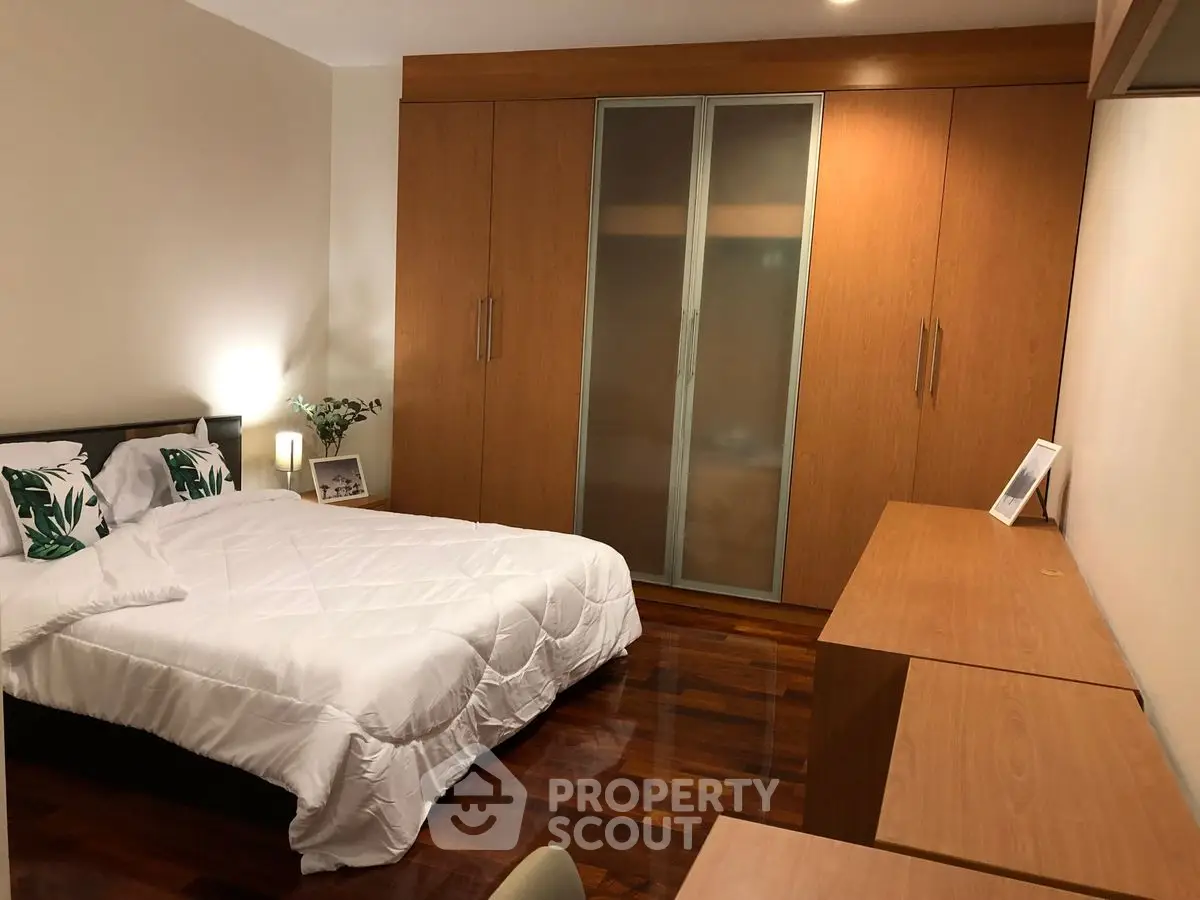 Spacious bedroom with wooden flooring and ample closet space