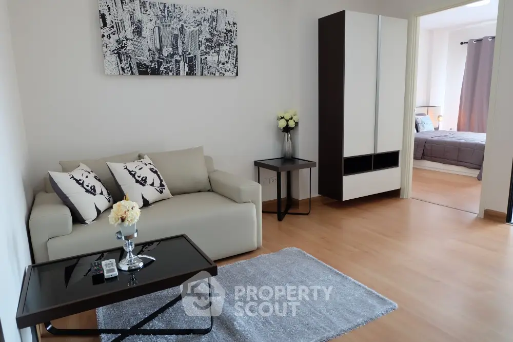 Modern living room with elegant decor and view into cozy bedroom