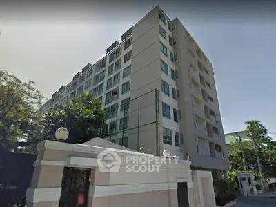 Modern multi-story residential building with lush greenery and secure entrance.