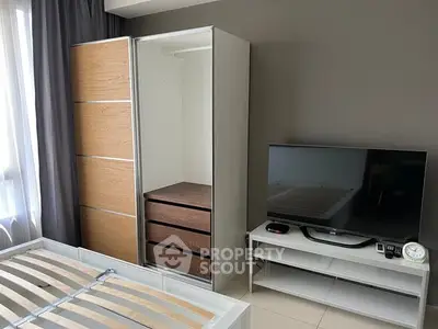 Modern bedroom with sleek wardrobe and flat-screen TV, perfect for contemporary living.