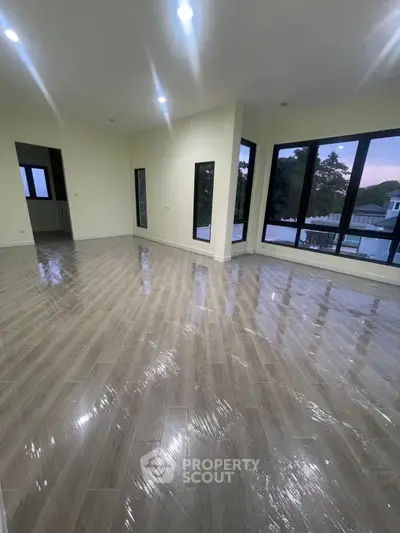 Spacious corner unit with large windows and glossy flooring, offering abundant natural light and serene views.