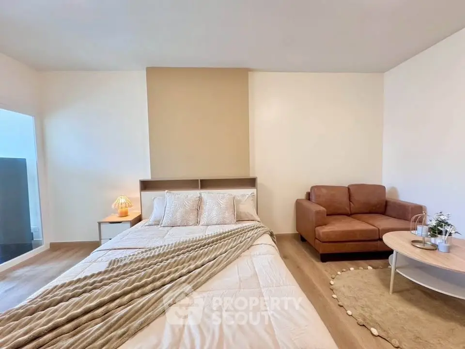 Spacious bedroom with cozy seating area and modern decor