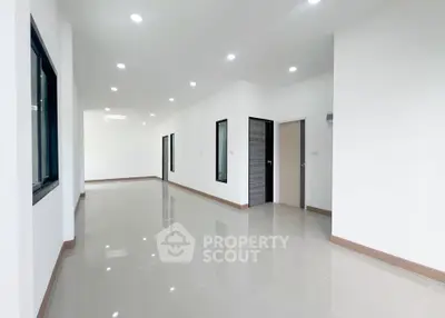 Spacious modern interior with sleek tile flooring and ample natural light, perfect for versatile living spaces.