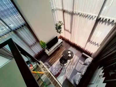 Stunning high-ceiling living room with floor-to-ceiling windows and modern decor.