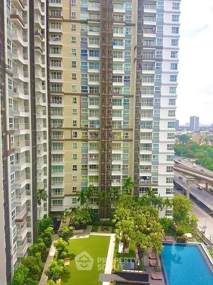 High-rise residential building with pool and garden view, showcasing modern urban living.