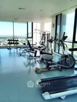 Spacious modern gym with city view in luxury apartment building