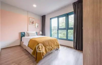 Bright and cozy bedroom with large window and modern decor, perfect for relaxation.