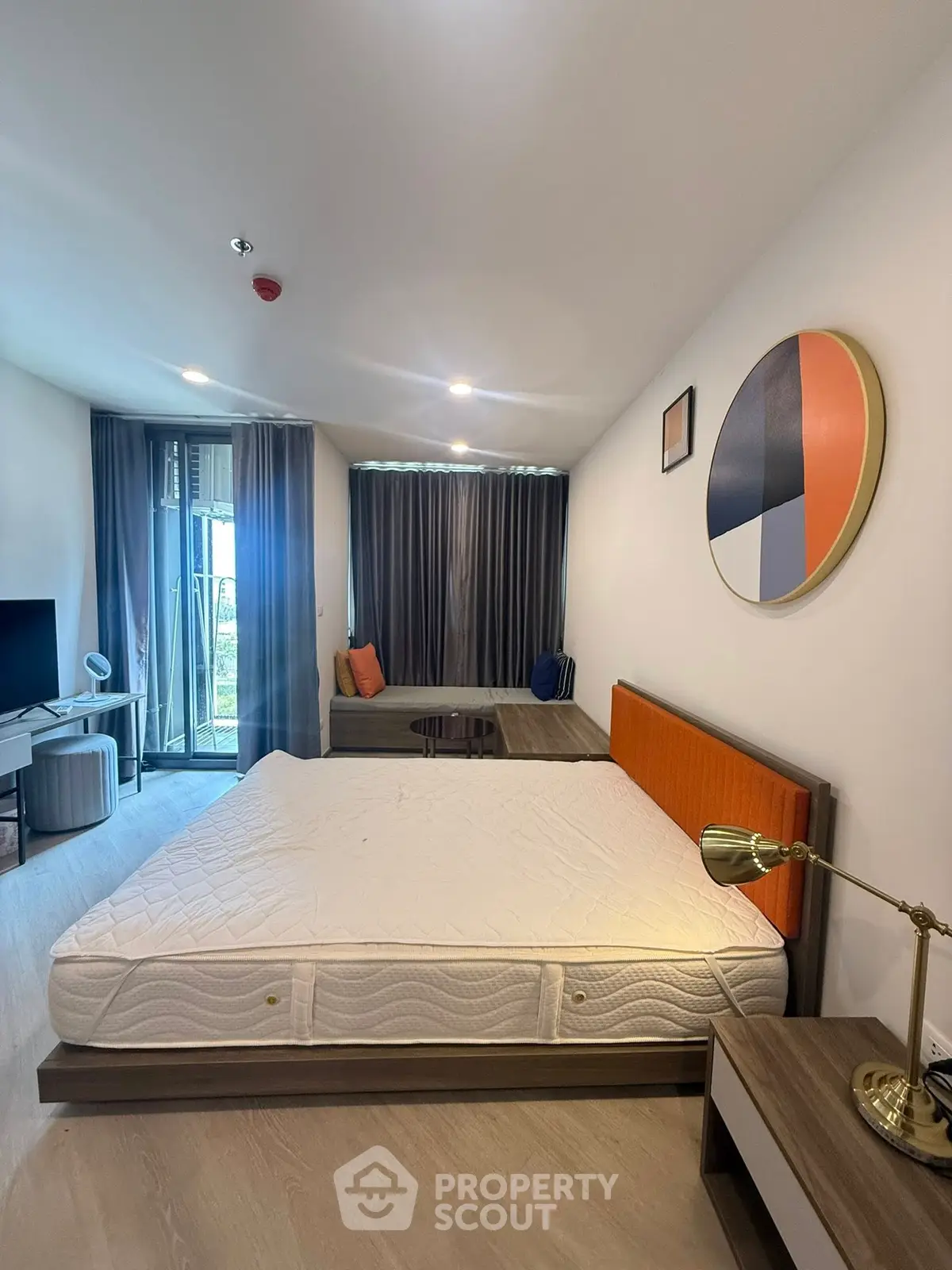 Modern bedroom with stylish decor and balcony access in a contemporary apartment.