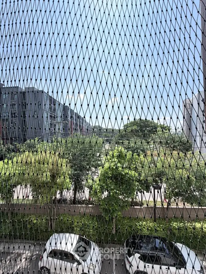 Scenic view from a balcony with lush greenery and modern buildings