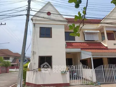 Charming townhouse with red roof and gated entrance in a serene neighborhood.