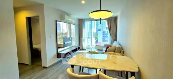 Modern living room with dining area and large windows in a stylish apartment.