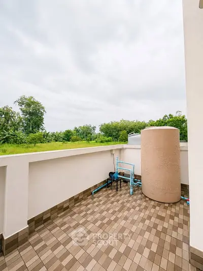 Spacious balcony with scenic greenery view and utility area, perfect for relaxation and outdoor activities.