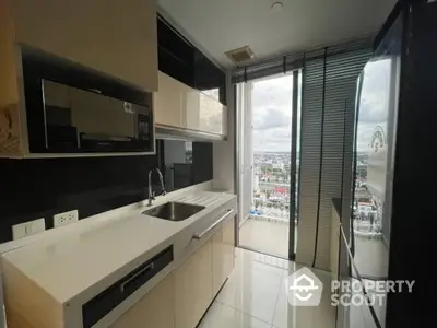 Modern kitchen with sleek cabinetry and stunning city view from balcony.