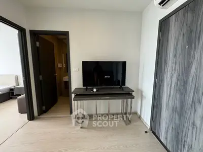 Modern apartment interior with sleek TV setup and stylish wooden flooring.