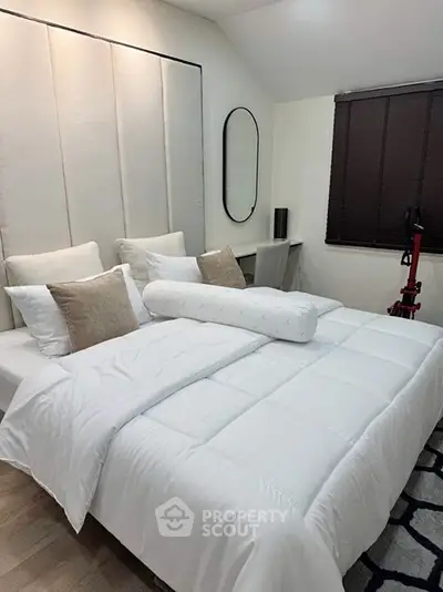 Cozy bedroom with modern decor and plush bedding, perfect for relaxation.