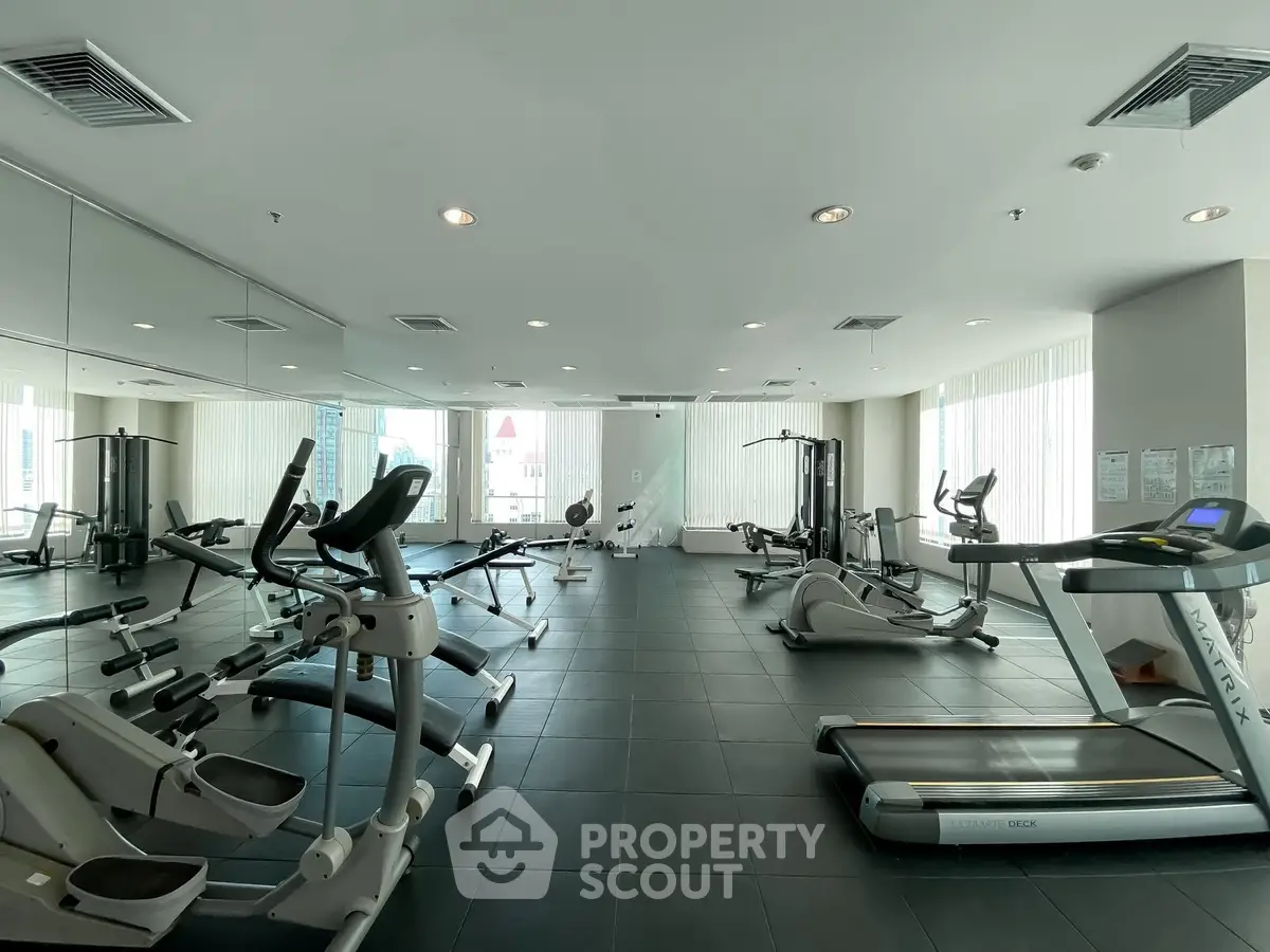 Spacious modern gym with state-of-the-art fitness equipment and large mirrors, perfect for an active lifestyle.