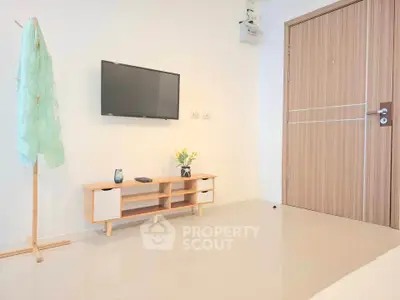 Modern minimalist living room with wall-mounted TV and stylish wooden furniture.