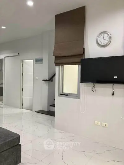 Modern living room with sleek marble flooring and wall-mounted TV