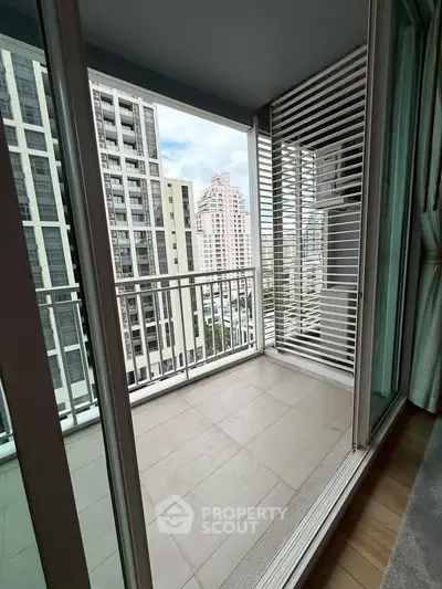 Modern balcony with city view in high-rise apartment, featuring sleek design and spacious layout.
