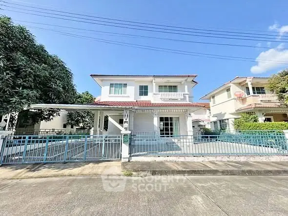 Charming two-story house with spacious front yard and gated entrance in a serene neighborhood.