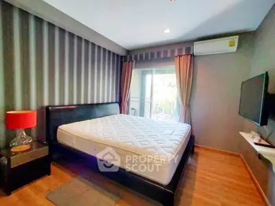 Modern bedroom with stylish decor and balcony access in a contemporary apartment.