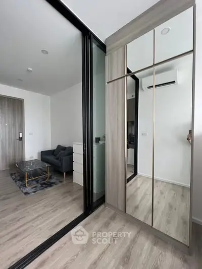 Modern apartment interior with mirrored wardrobe and cozy living area.