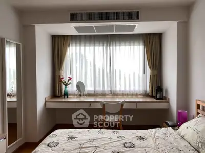 Cozy bedroom with large window, elegant curtains, and stylish decor, perfect for relaxation and comfort.