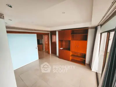 Spacious living room with built-in wooden cabinets and large windows