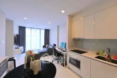 Modern open-plan living room and kitchen with sleek design and natural light.