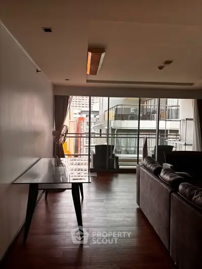 Spacious living room with modern furniture and large windows offering city views.