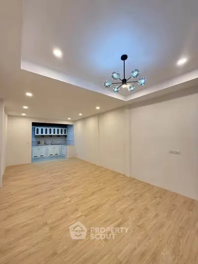 Spacious modern living room with elegant lighting and open kitchen layout