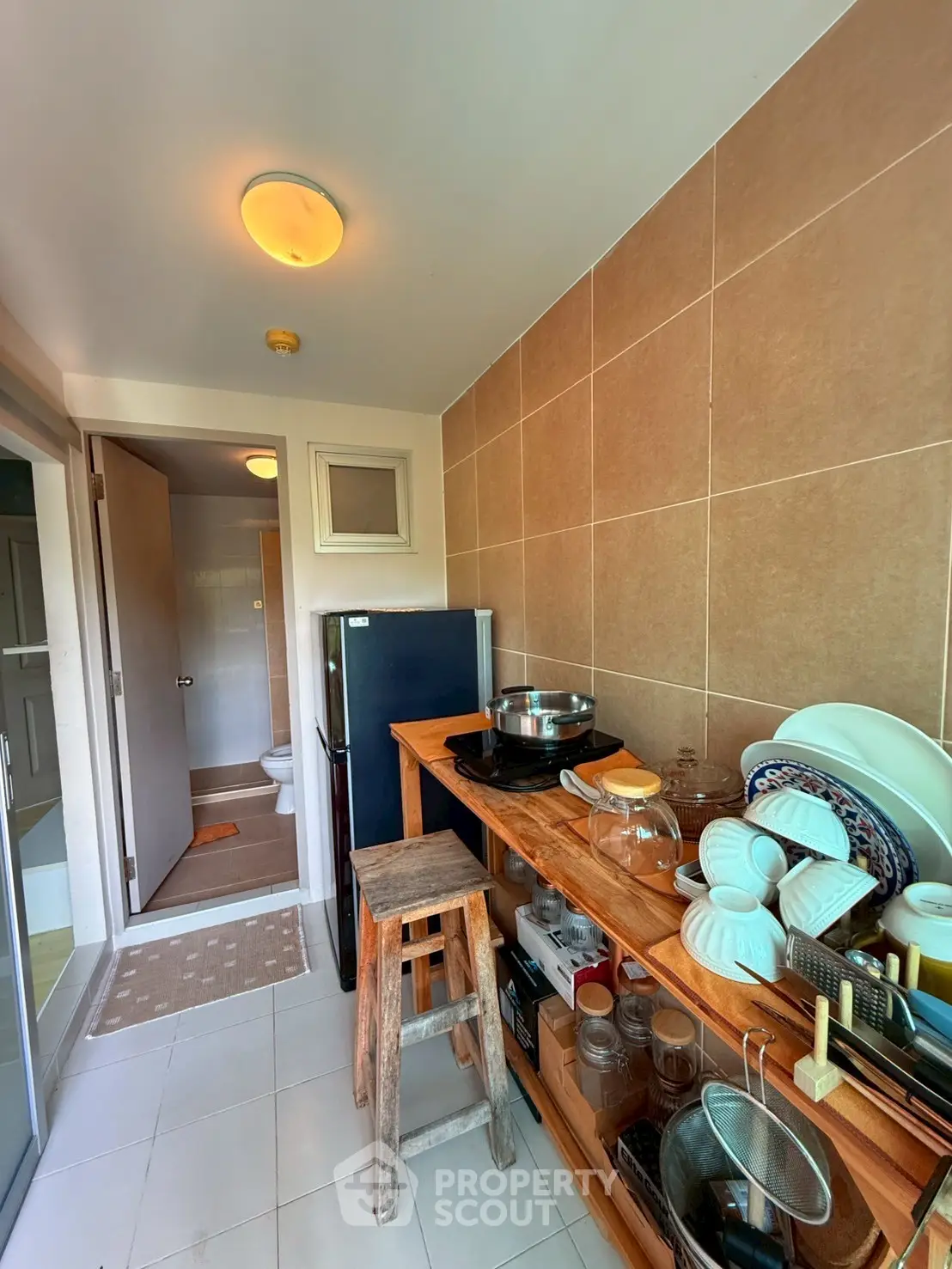 Cozy kitchen with wooden shelves and modern appliances in a compact layout.