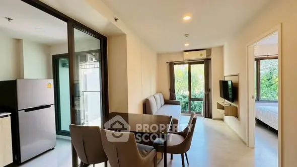 Modern apartment with open living and dining area, featuring large windows and natural light.