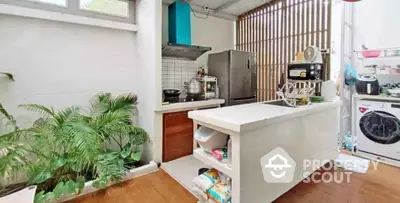 Modern kitchen with island, stainless steel appliances, and indoor plants