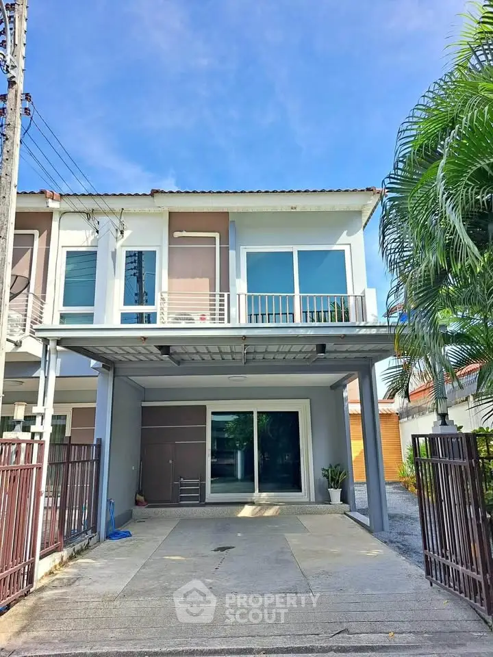 Modern two-story townhouse with spacious driveway and balcony, perfect for family living.