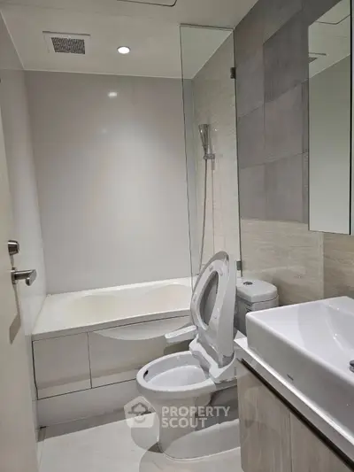 Modern bathroom with sleek fixtures and a bathtub in a contemporary apartment.