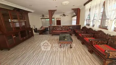 Spacious living room with elegant wooden furniture and large windows for natural light.